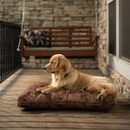 Golden retriever lying on a Pendleton dog bed with a brown floral pattern on a wooden porch